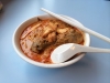 Curry Noodle - Thai Nudelgericht mit Tofustreifen, ganzer Hähnchenkeule und scharfer Curry-Soße